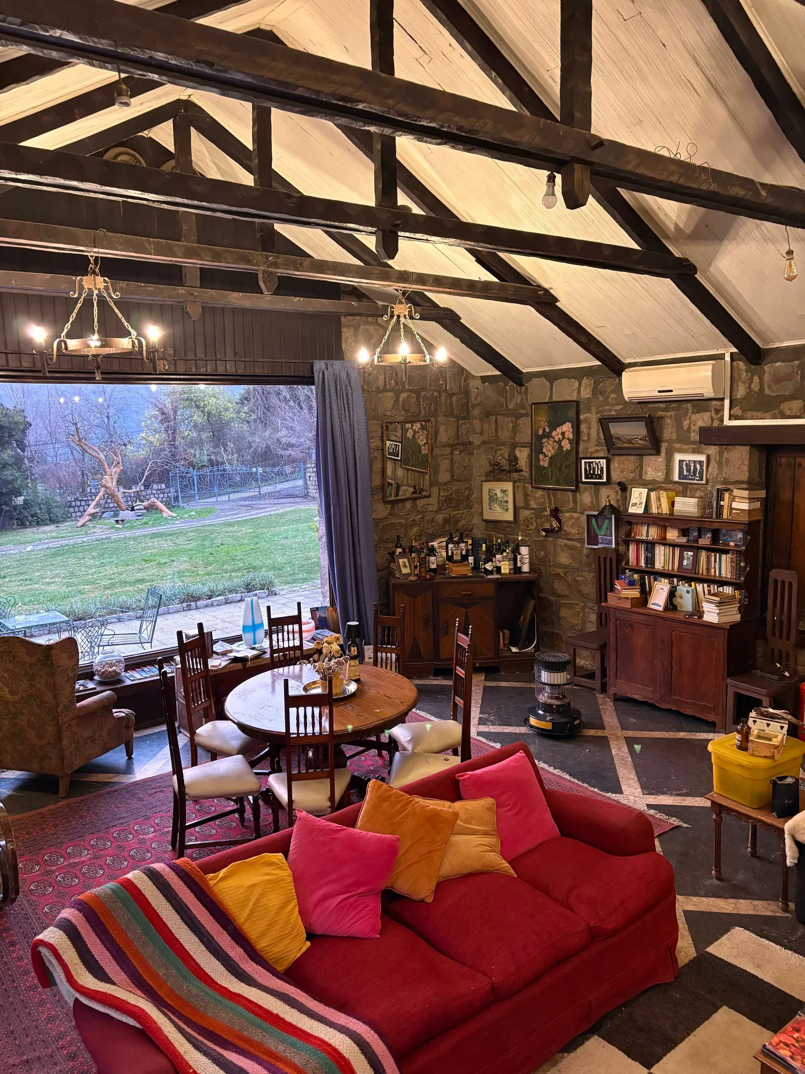 El gran salón: la biblioteca, el sofá rojo y el ventanal al jardín