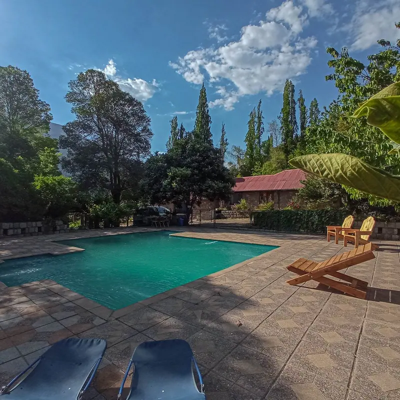 Sillas de madera junto a la piscina