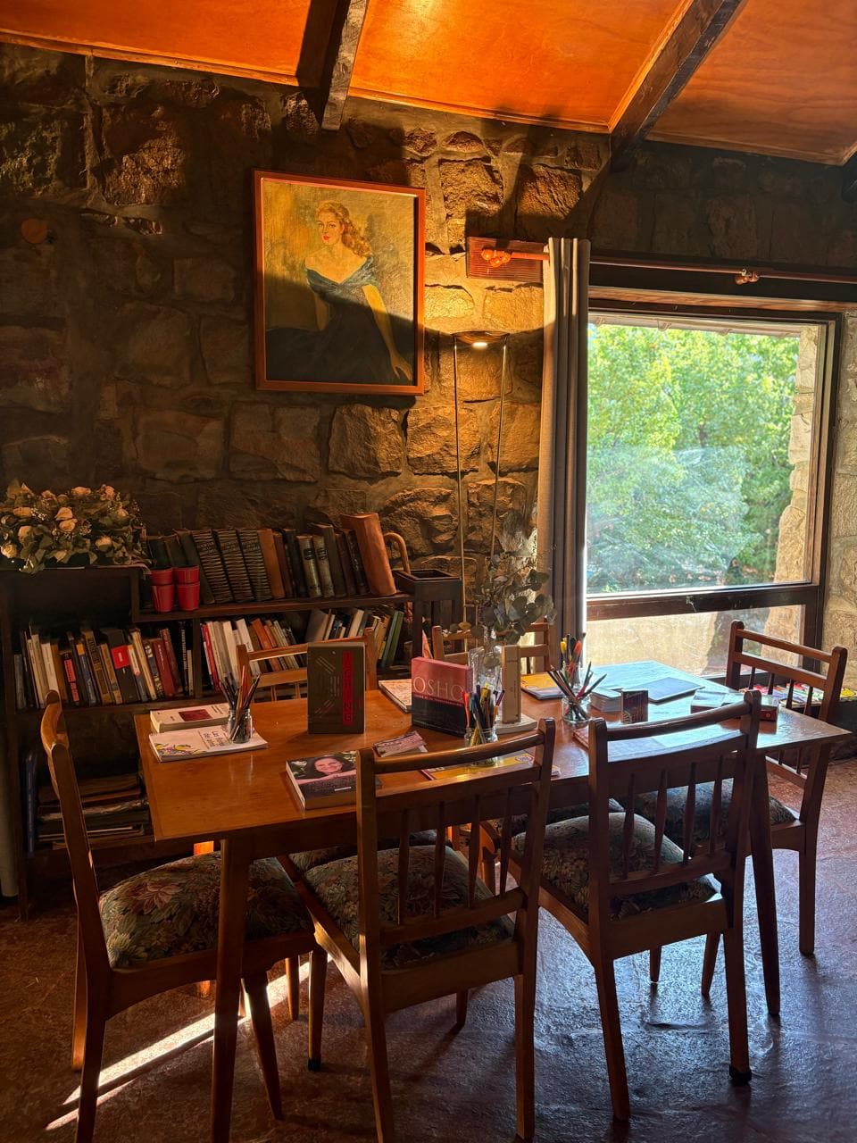 Comedor con estantería de libros y ventana al jardín